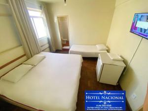 a small room with two beds and a sign that says hoteladium at Hotel Nacional Montes Claros in Montes Claros +1 photo
