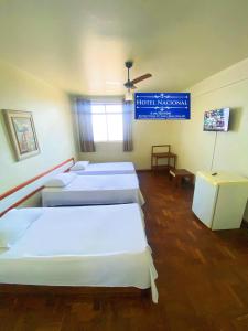 a room with four beds and a sign that reads hotel korea at Hotel Nacional Montes Claros in Montes Claros