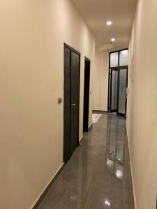 a hallway with two black doors and a hallway with a floor at The One in Yaoundé +45 photos