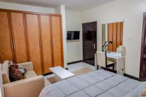 een slaapkamer met een bed en een bureau bij EZRA BOUTIQUE Hotel By The Weekender Ltd in Kigali