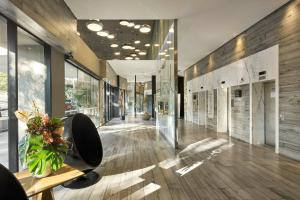 a lobby of a building with wooden floors and glass walls at Radisson Blu Belo Horizonte Savassi in Belo Horizonte