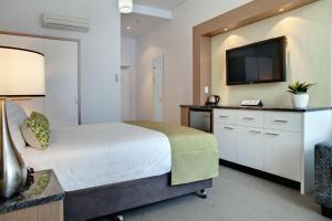 1 dormitorio con 1 cama y TV de pantalla plana en Walkers Arms Hotel, en Adelaida