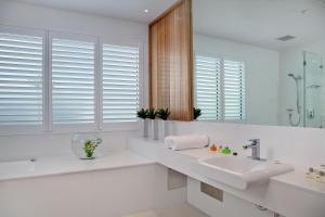 a white bathroom with a sink and a mirror at Walkers Arms Hotel in Adelaide