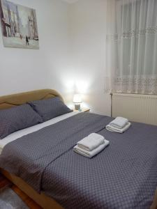 1 dormitorio con 1 cama con 2 toallas en Apartman City, en Bijeljina