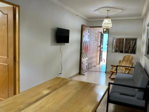 sala de estar con mesa de madera y TV en Apartamentos Primavera en Jardín