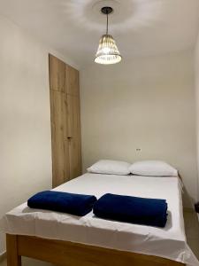 a bedroom with a bed with two blue pillows at Apartamentos Primavera in Jardin