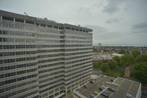 a tall building with a parking lot in front of it at Modern, 2-bedroom Central Southend flat,9th Floor in Southend-on-Sea