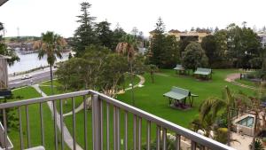 a balcony with a view of a park with picnic tables at Boat Harbour Motel in Wollongong