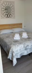 een slaapkamer met een bed met handdoeken erop bij Casa Marta in Enas
