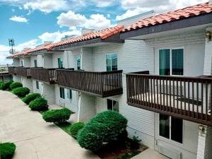 een appartementencomplex met balkons en struiken bij Hotel Inn Santa Fe in Santa Fe