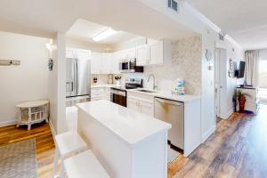 a kitchen with white cabinets and a white counter top at Island Echoes 1F in Fort Walton Beach