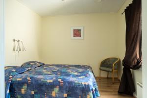 ロヴァニエミにあるHotel Aakenus Holiday Home Kokkiのベッドルーム1室(ベッド1台、椅子付)