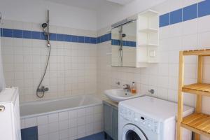 Vienna Living Apartments - Hödlgasse في فيينا: حمام مع حوض استحمام وغسالة ملابس