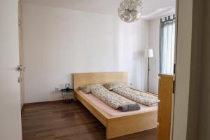Vienna Living Apartments - Hödlgasse في فيينا: غرفة نوم مع سرير مع لوح خشبي للرأس