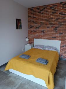 a bed in a room with a brick wall at Apartament Łodzianka in Łódź