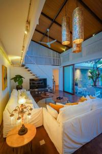 un soggiorno con un divano bianco e un tavolo di Bias Villa Seminyak a Seminyak
