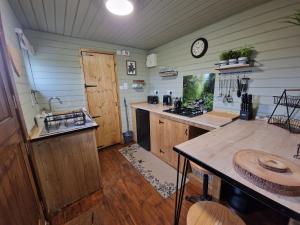a kitchen with a counter and a clock on the wall at Stunning 1-Bed shepherd hut in Holyhead in Holyhead