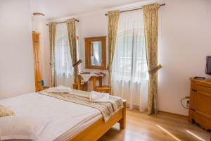 1 dormitorio con cama y ventana en Popasul Craiului en Zărneşti