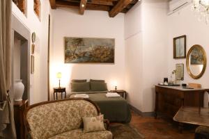 a bedroom with a bed and a chair and a mirror at Casa Gori in Florence