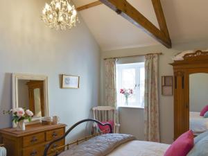 1 dormitorio con cama, tocador y espejo en Calf House Cottage en Sedgefield