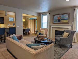 een woonkamer met een bank en stoelen en een open haard bij Spacious 3-bedroom home with outdoor space in Eugene