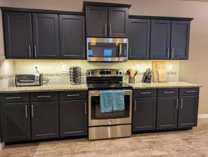 uma cozinha com armários pretos e electrodomésticos de aço inoxidável em Spacious 3-bedroom home with outdoor space em Eugene