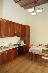 a kitchen with wooden cabinets and a table with a tablecloth at I Due Principi in San Marco Argentano