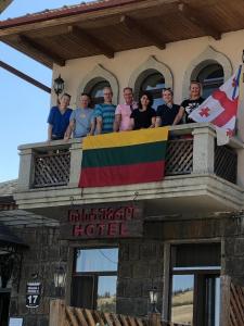 un gruppo di persone che si trova su un balcone con una bandiera di Golden Gate a Akhaltsikhe