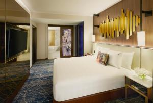 a bedroom with a large white bed and a television at Hard Rock Hotel New York in New York