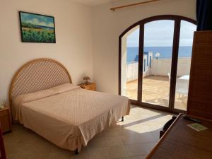 a bedroom with a bed and a view of the ocean at Hotel Miramare Garzia in Marinella di Selinunte