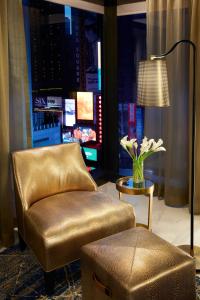 a living room with a chair and a table with flowers at Hard Rock Hotel New York in New York
