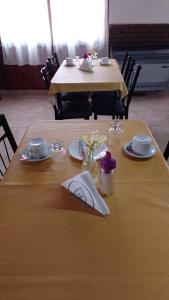 una mesa de madera con platos y servilletas. en Hotel Atlantic en Mar de Ajó
