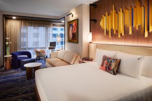 a hotel room with a bed and a living room at Hard Rock Hotel New York - Partner of ALL Accor in New York