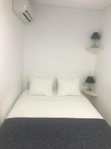 - un lit blanc avec 2 oreillers blancs et 2 lampes dans l'établissement O Pátio, à Fernão Ferro