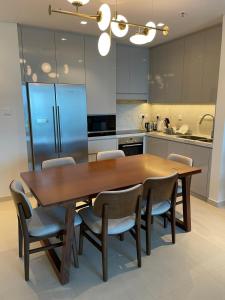 una cucina con tavolo in legno e alcune sedie di Sharm 3 Bedroom Luxury Apartment a Sharm