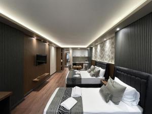 イスタンブールにあるGRAND ÜSKÜDAR OTELのベッド2台とテレビが備わるホテルルームです。