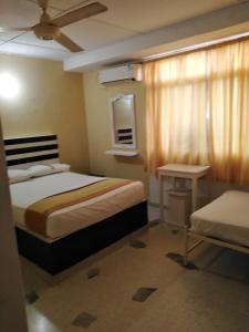 Dormitorio pequeño con cama y mesa en HOSTAL PARMA, en Santa Marta