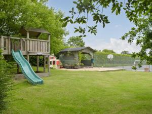 un parque infantil con un tobogán en un patio en Oak Cottage - Uk11212, en Walton West