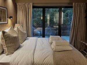 拉姆斯博頓的住宿－Apartments for two in Brand New Luxury Rural Farmhouse Escape，卧室内的一张带白色床单和枕头的床