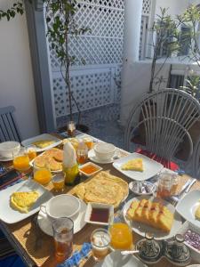 a table topped with plates of food and orange juice at RIAD MAROSKO in Essaouira