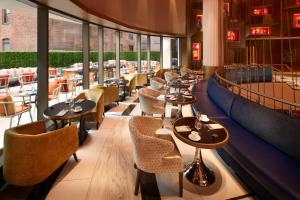 ein Restaurant mit Tischen, Stühlen und Fenstern in der Unterkunft Hard Rock Hotel New York in New York