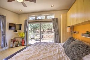 - une chambre avec un lit et une porte coulissante en verre dans l'établissement Sleek, Modern Sedona Home with Rock Views and Hot Tub!, à Sedona