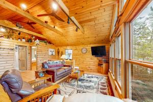 a log cabin living room with a couch and a tv at Camp Two Loons in Oxford