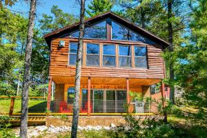 a cabin in the woods with large windows at Camp Two Loons in Oxford