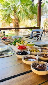 uma mesa de madeira com tigelas de comida em Bybassios Orhaniye em Orhaniye