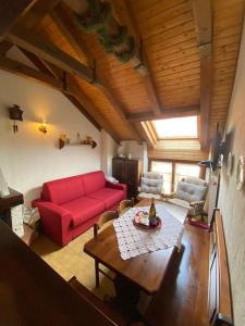 Zovello的住宿－La casa del Cucù al Ravascletto, 900mt from cable car，客厅配有红色的沙发和桌子
