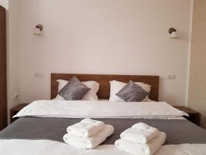 a bed with two folded towels on top of it at Resting House in Braşov