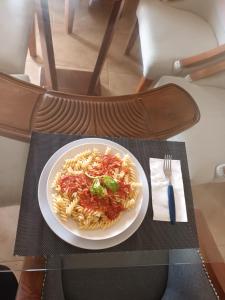 a plate of pasta on a table with a fork at Casa taina in Jarabacoa