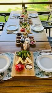 una larga mesa de madera con platos de comida. en Bybassios Orhaniye, en Orhaniye