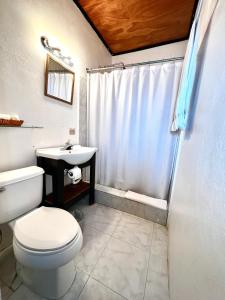 a bathroom with a white toilet and a sink at Habitation Des Lauriers in Cap-Haïtien